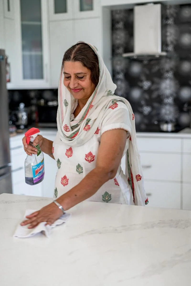 Cleaner wiping a kitchen surface.