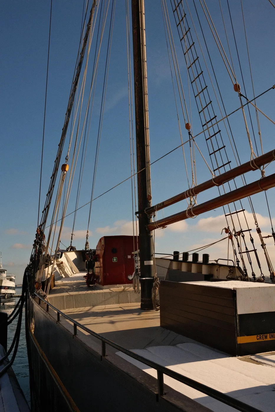 Sailboat moored beside a pier with its deck visible.