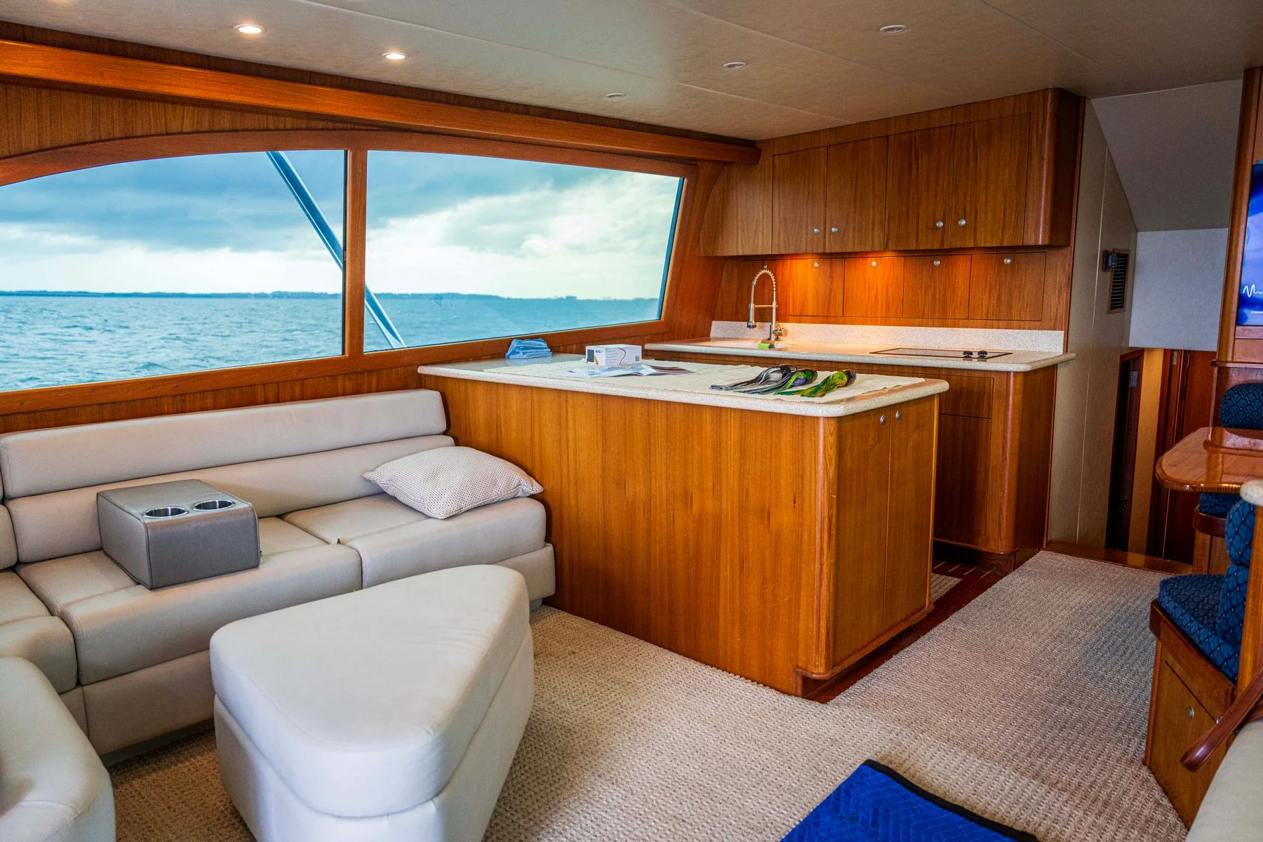 Sunlit yacht salon with wood furnishings and a sea view.
