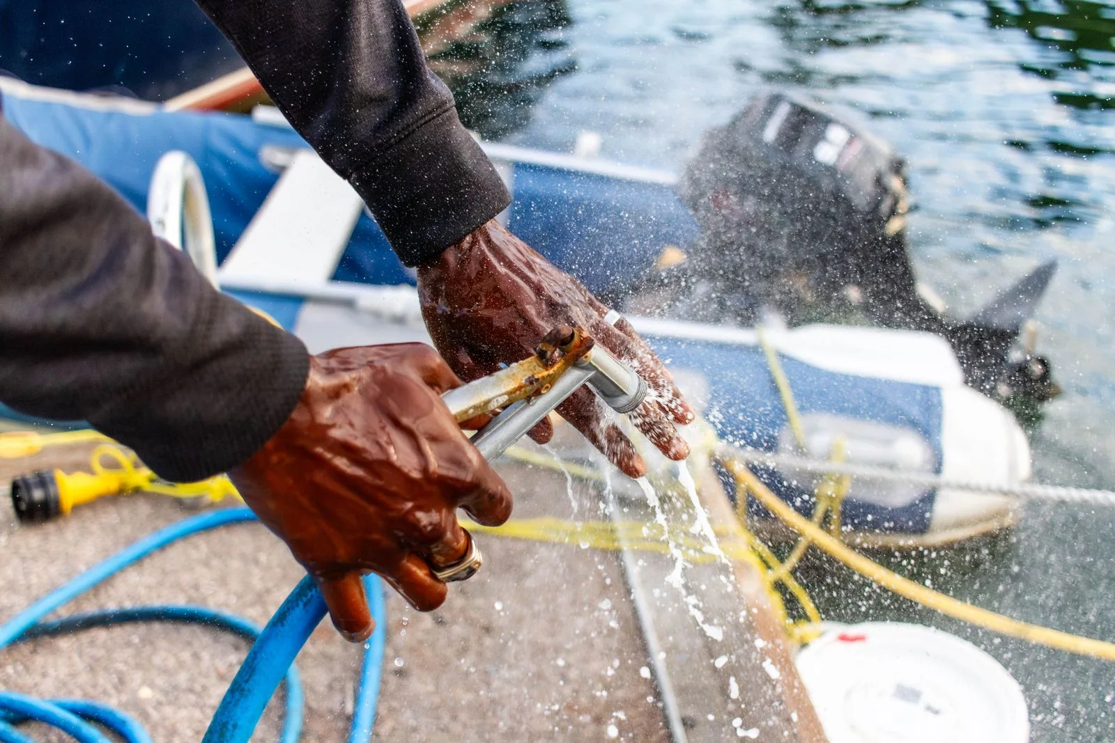 Cleaner washing a boat deck with water.