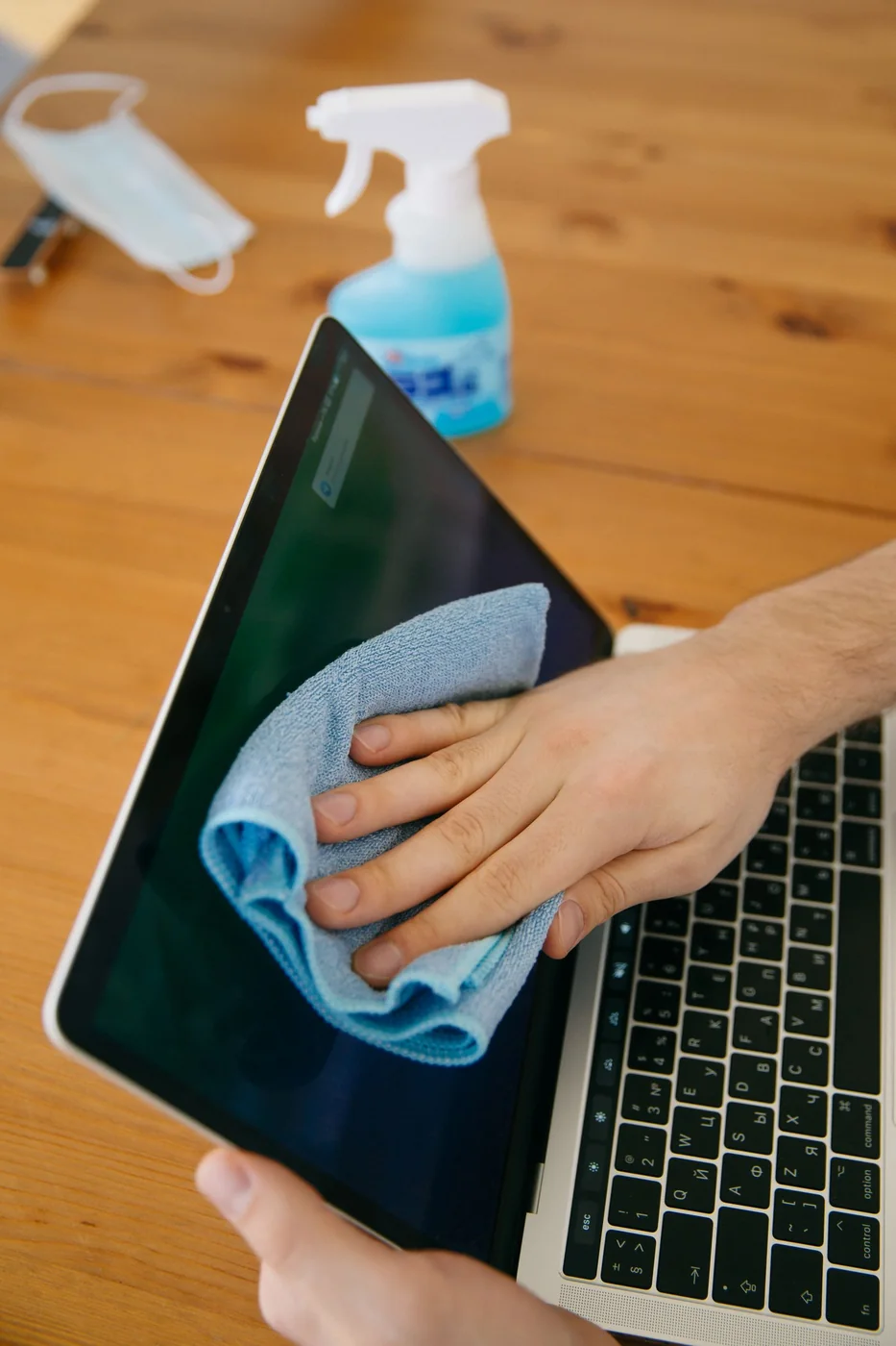 A hand cleaning a smooth glass surface.