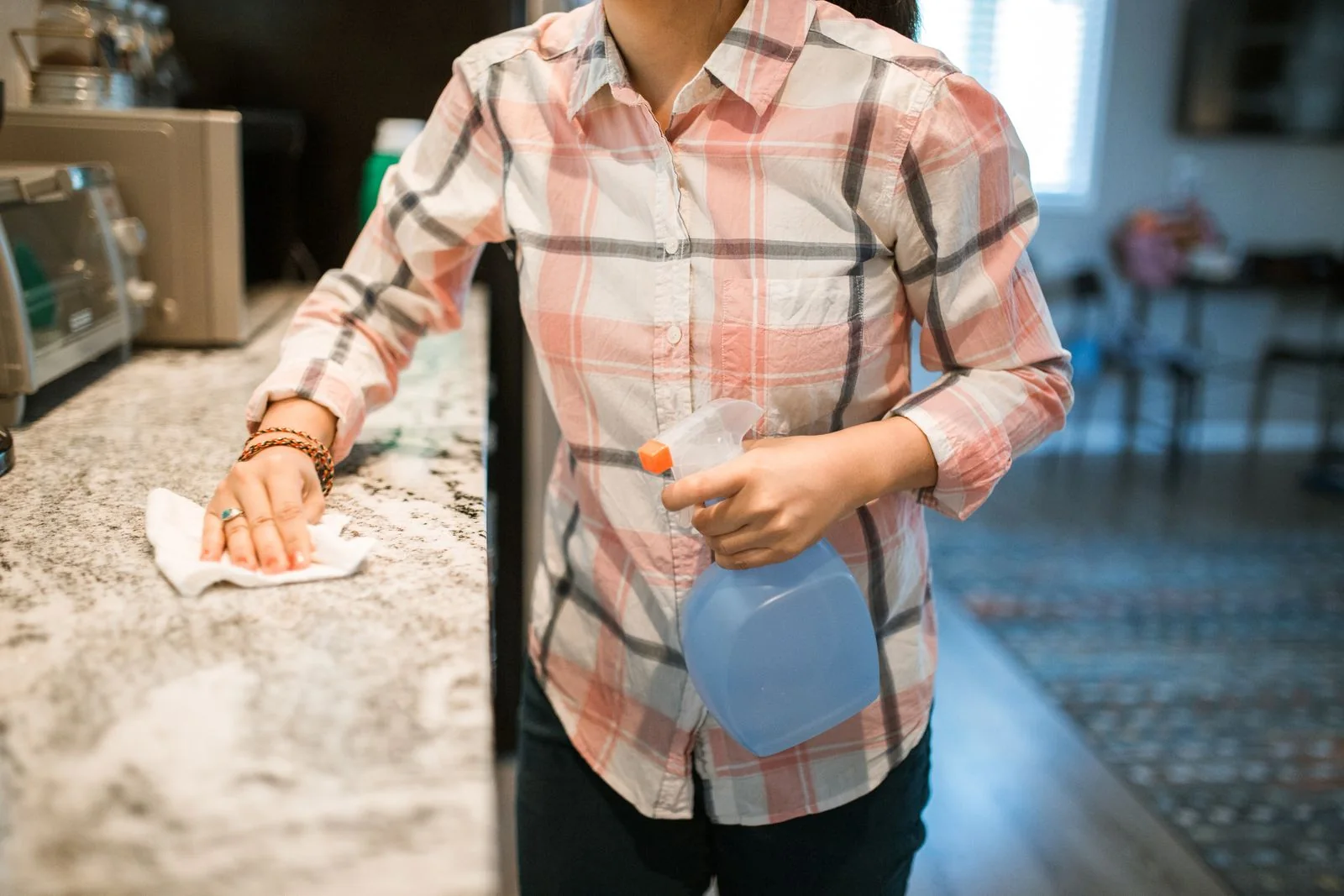 Person wiping a kitchen counter.