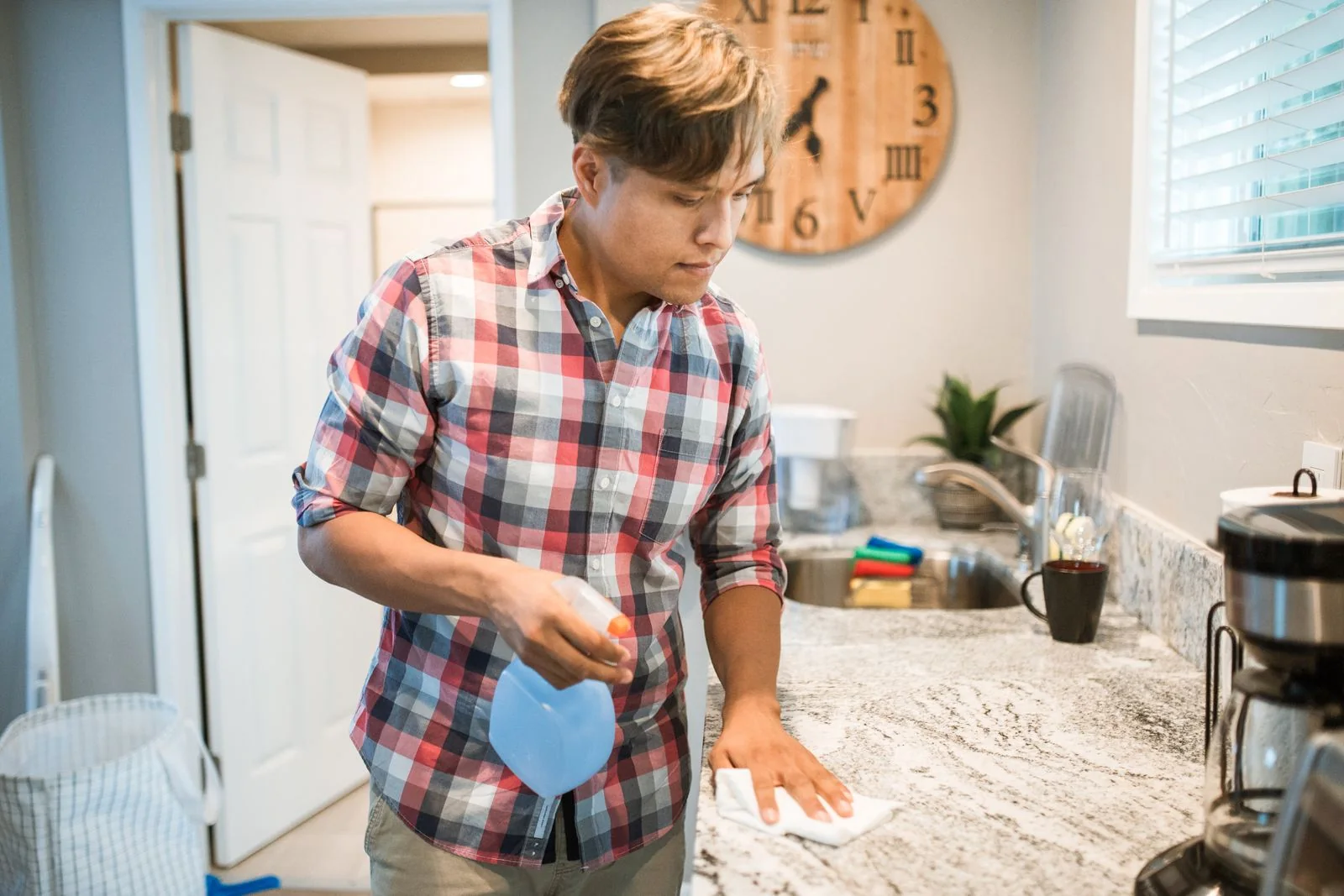 Person wiping a kitchen counter.