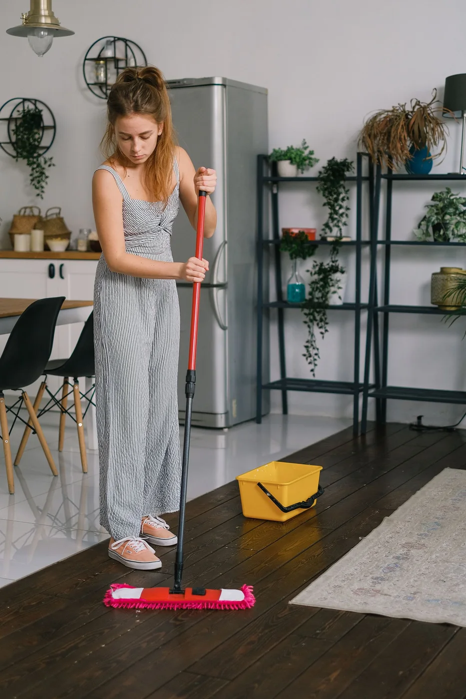 Woman mopping a wood floor at home.