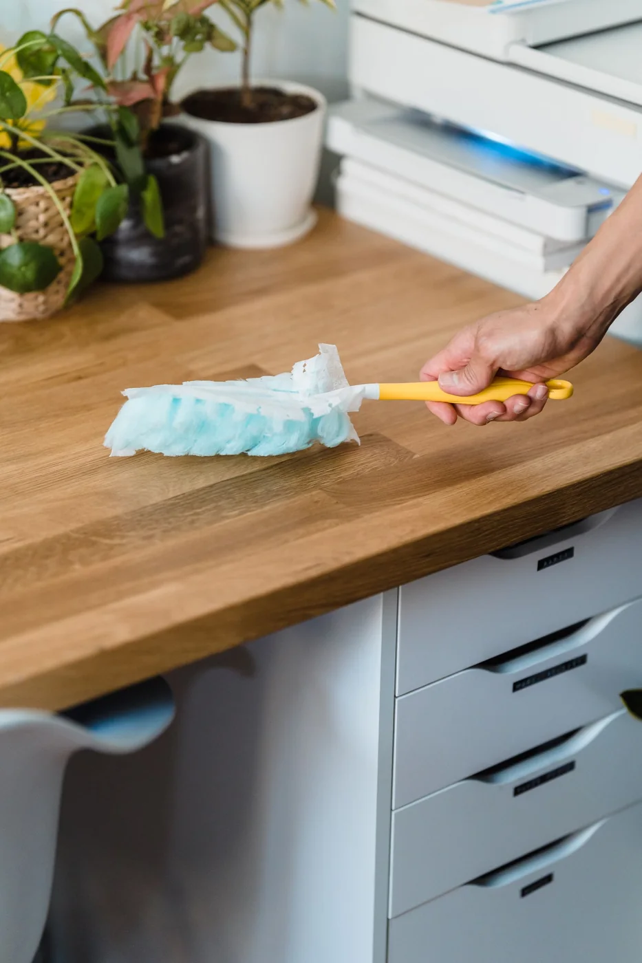 Hand wiping a wood surface.